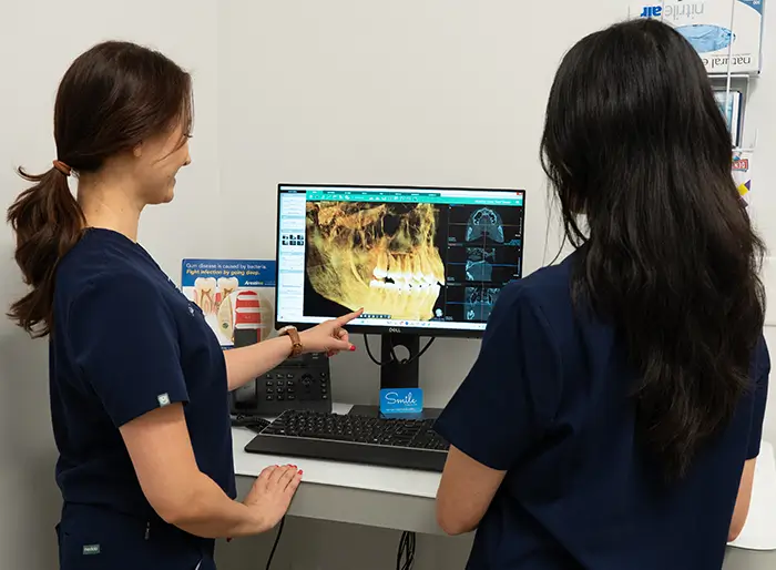 Two dental hygienists viewing a head x-ray.